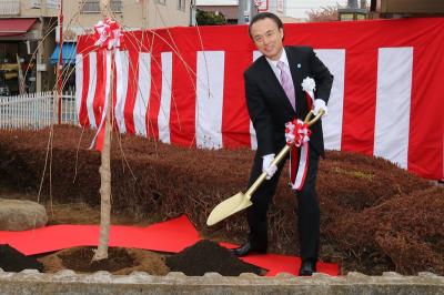 スコップで木に土をかける富岡市長