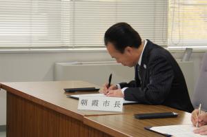 協定書に署名する富岡市長