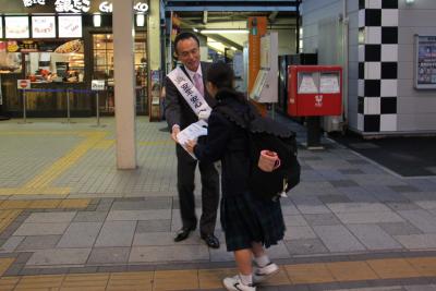 朝霞駅前で防犯啓発品を手渡しする富岡市長