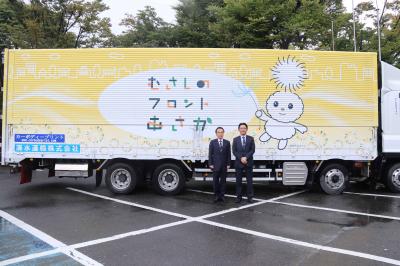 ぽぽたんのデザイントラック前で記念撮影する富岡市長と清水運輸グループの清水代表取締役