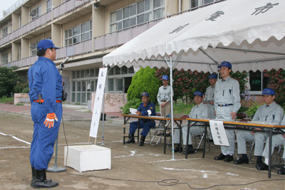 旧朝霞第一中学校での地域防災訓練で訓練の報告を受ける