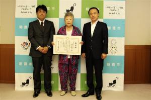 特別養護老人ホーム打間木苑の理事長と施設長が、埼玉県から受けたコバトン・ハートフルメッセージの表彰を手に、市長と一緒に記念撮影