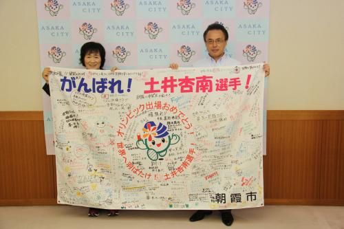 土井杏南選手への応援旗を持つ土井かよ子さんと市長