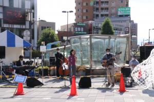 朝霞駅南口駅前広場にてライブをする人の様子