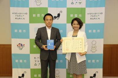 寄贈いただいた本を持つ富岡市長と感謝状を持つ今井様が写っています。