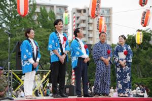 納涼大会の写真です。舞台上に来賓者がそろっています。