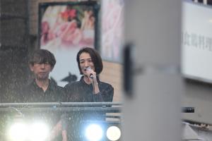 彩夏祭前夜祭であいさつをする松下市長の様子です。雨が降りしきる中、マイクを手に松下市長があいさつをしています。