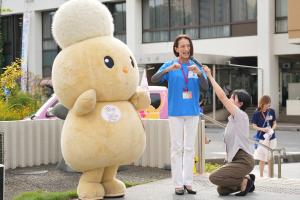 デフリンピックPRカー来庁時の写真です。松下市長が手話をしながらあいさつし、市キャラクターのぽぽたんと一緒に写っています。