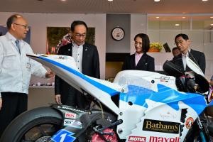 ふれあい訪問の様子の写真です。エムテック作成のレーシングバイクについて説明を受ける大野埼玉県知事、松下朝霞市市長、岡崎市議会議長が写っています