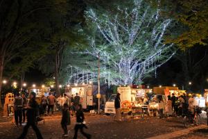 アサカストリートテラスの様子です。夜に実施された冬のあかりテラスのイルミネーションプレ点灯と、ストリートテラスの出店ライトアップが相まって、幻想的な光景が広がっています。