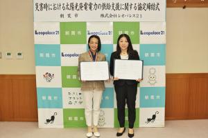 協定締結式の様子の写真です。松下市長と株式会社レオパレス21の取締役がそれぞれ協定書手にして写っています。