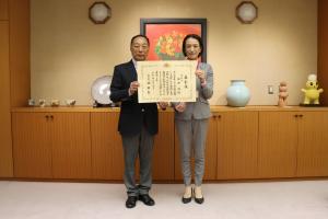 表敬訪問の記念写真です。醍醐町内会長と松下市長が表彰状を手に写っています。