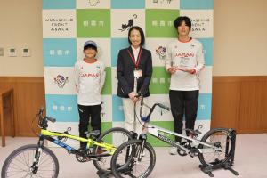 表敬訪問の記念写真です。大会で使用したBMXを前に並べ、両選手と市長が写っています。