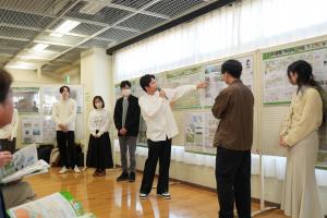 キックオフイベントと同時開催の公益社団法人日本造園学会関東支部の学生デザインワークショップ提案発表の様子です。学生が各自で作成した街づくりに関する提案のパネルの前で来場へ説明を行っています。
