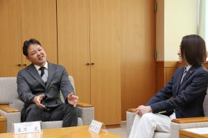 感謝状贈呈式の様子の写真です。代表取締役と市長が椅子に座り、談笑しています。