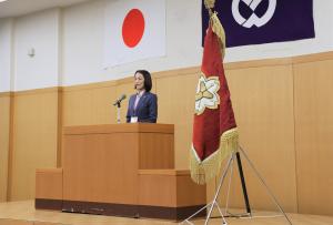 辞令交付式のあいさつの様子の写真です。市長が壇上でマイクにむかって話しています。
