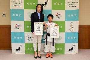 表敬訪問の記念写真です。松下市長と三村選手が表彰状を手にして写っています。