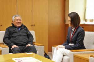 感謝状贈呈式の様子の写真です。寄贈されたシールを見ながら松下市長と代表取締役社長が歓談しています。
