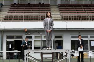 シニアスポーツフェスティバルのあいさつの様子の写真です。金属の檀上にあがった松下市長が、マイクを使ってあいさつを行っています。
