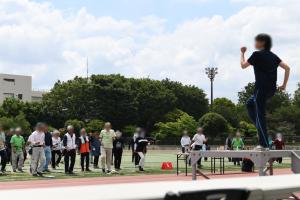 シニアスポーツフェスティバルの様子の写真です。競技開始前に、参加者の皆さんで準備体操を行っています。
