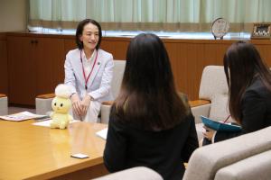 取材の様子の写真です。2人の学生記者を前に、松下市長が質問に答えています。