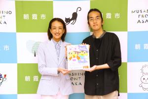 表敬訪問の記念写真です。松下市長とじゅうきゅうさいさんが朝霞あにあねの色紙を手に笑顔で写っています