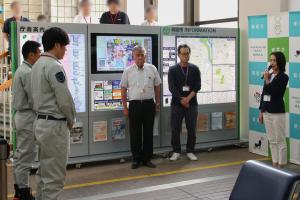 出発式の様子の写真です。派遣される職員の前で市長が激励を行い、教育長と副市長が見守っています。